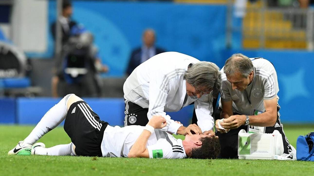 Dr. Hans Wilhelm Müller-Wohlfahrt (l.) und Wolfgang Bunz (r.) betreuen den am Boden liegenden Sebastian Rudy