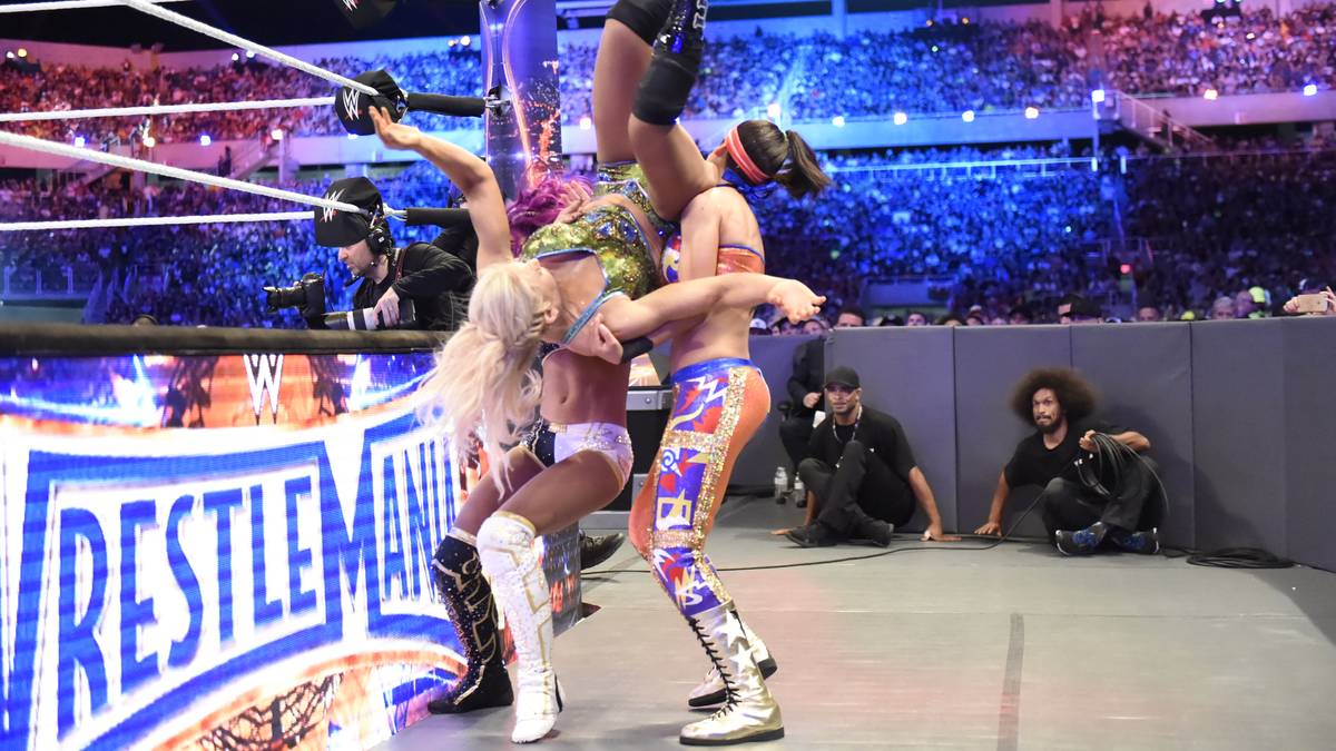 An Athletik stehen die Damen den Herren in nichts nach, hier fliegt Charlotte Flair (genau, die Tochter von Ric) auf Banks und RAW-Champion Bayley (r.)