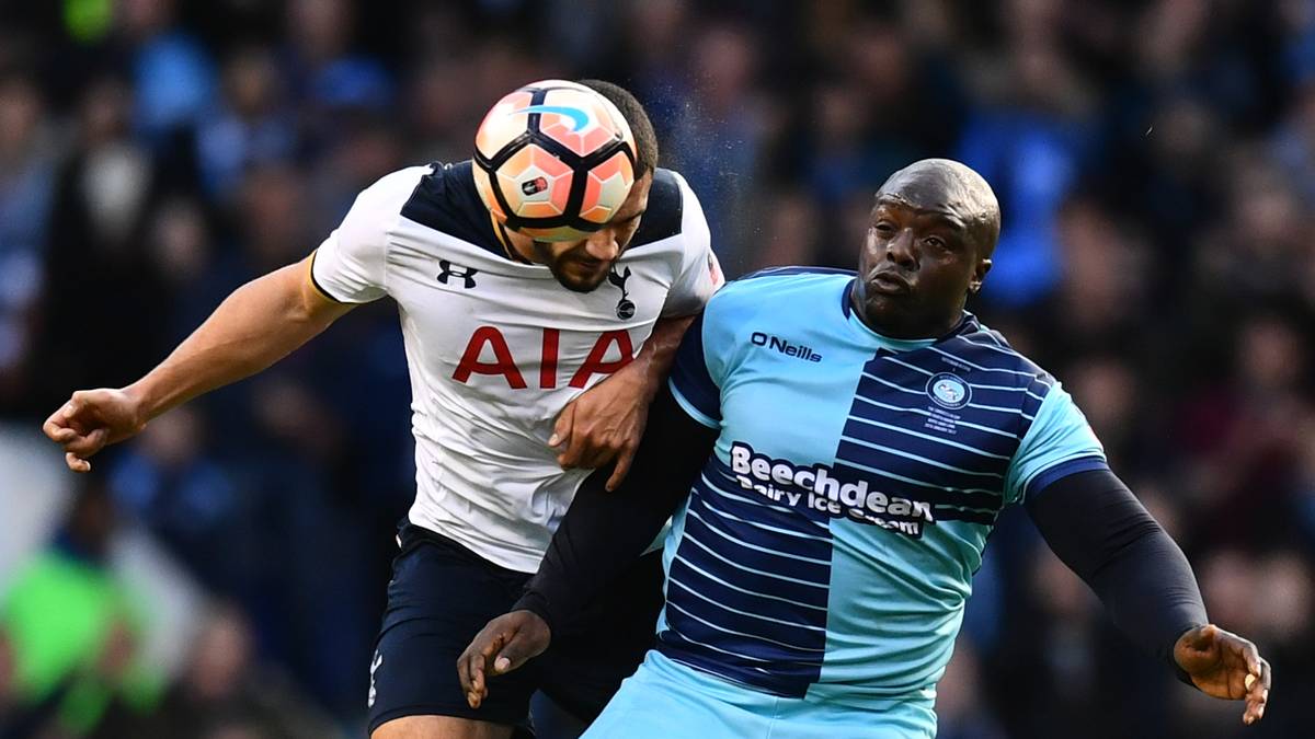 ADEBAYO AKINFEWA (Wycombe Wanderers): 1,80 Meter groß und 100 Kilogramm Lebendgewicht. Das sind die Maße von "The Beast". Der Stürmer schoss Ende Mai 2016 den AFC Wimbledon Ende im Playoff-Finale in die 3. Liga und das, obwohl sein Vertrag nicht verlängert werden sollte. Nach dem Finale bat er in einem Interview Trainer anderer Vereine sich bei ihm per WhatsApp zu melden