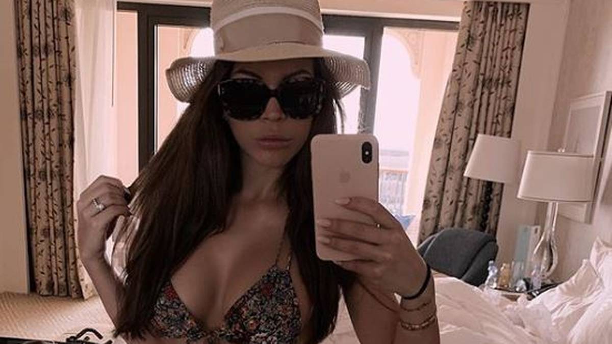 Ina Aogo fotografiert sich mit dicker Sonnenbrille und Strohhut