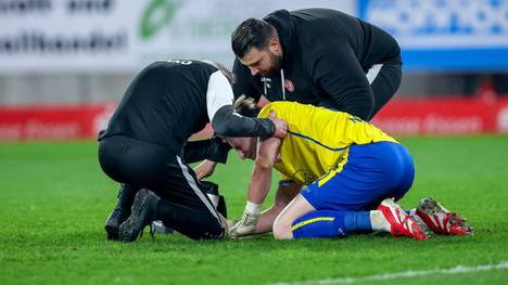 Sorge um Essen-Torwart Felix Wienand. Nachdem ein Böller direkt neben dem Schlussmann explodiert ist, wurde die Partie zwischen Essen und Mannheim minutenlang unterbrochen. Für Wienand endet die Partie, denn er muss ins Krankenhaus.