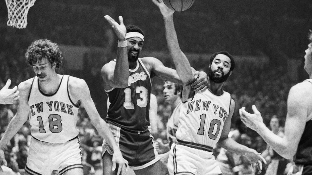 RANG 6 - LOS ANGELES LAKERS vs. NEW YORK KNICKS: Innerhalb von vier Jahren stehen sich zwischen 1970 und 1973 die Knicks und Lakers dreimal in den Finals gegenüber. Nach je einem Erfolg trägt Walt Frazier (r.) die Knicks 1973 zum 2. Titel. Legendär ist auch der Kurzauftritt des verletzten Knicks-Stars Willis Reed in Spiel 7 1970. Der junge Mann links ist übrigens der spätere Erfolgstrainer Phil Jackson