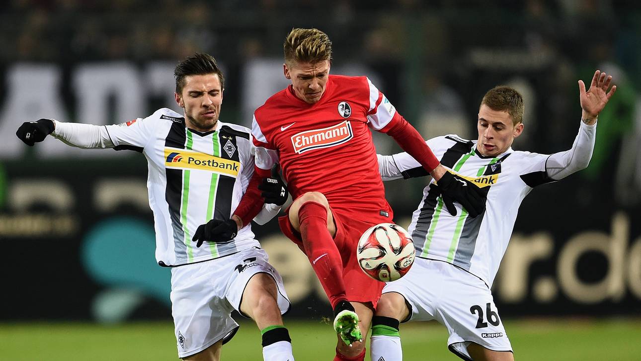 Mike Frantz vom SC Freiburg gegen zwei Gladbacher