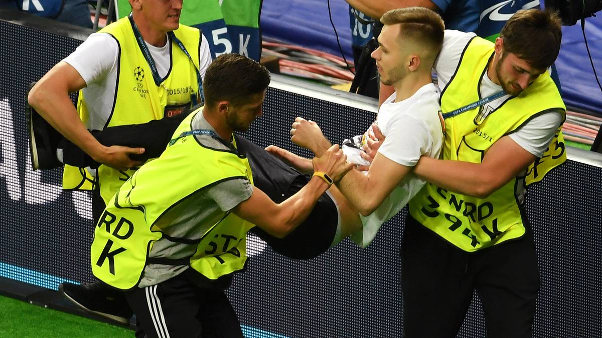 Der junge Mann wird aber schnell von den Securitykräften erwischt und vom Platz getragen