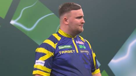 Luke Littler steht in Runde drei der Darts-WM. Dabei muss sich der aktuelle Weltmeister aber einen entscheidenden Moment im ersten Satz überstehen. 