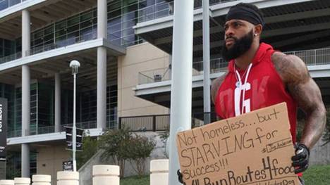 Joe Anderson steht mit seinem Schild vor dem Stadion in Houston
