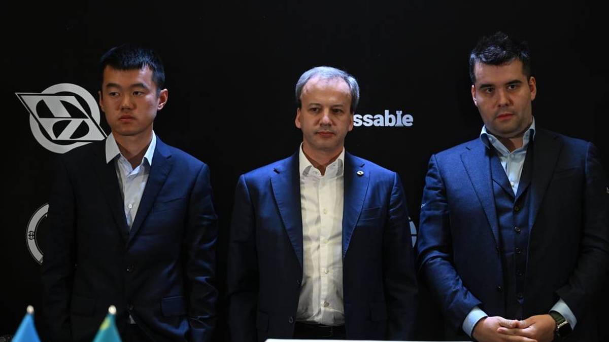 Ding Liren (l.) und Jan Nepomnjaschtschi machen den WM-Titel im Schach unter sich aus - in der Mitte: FIDE-Präsident Arkadi Dworkowitsch