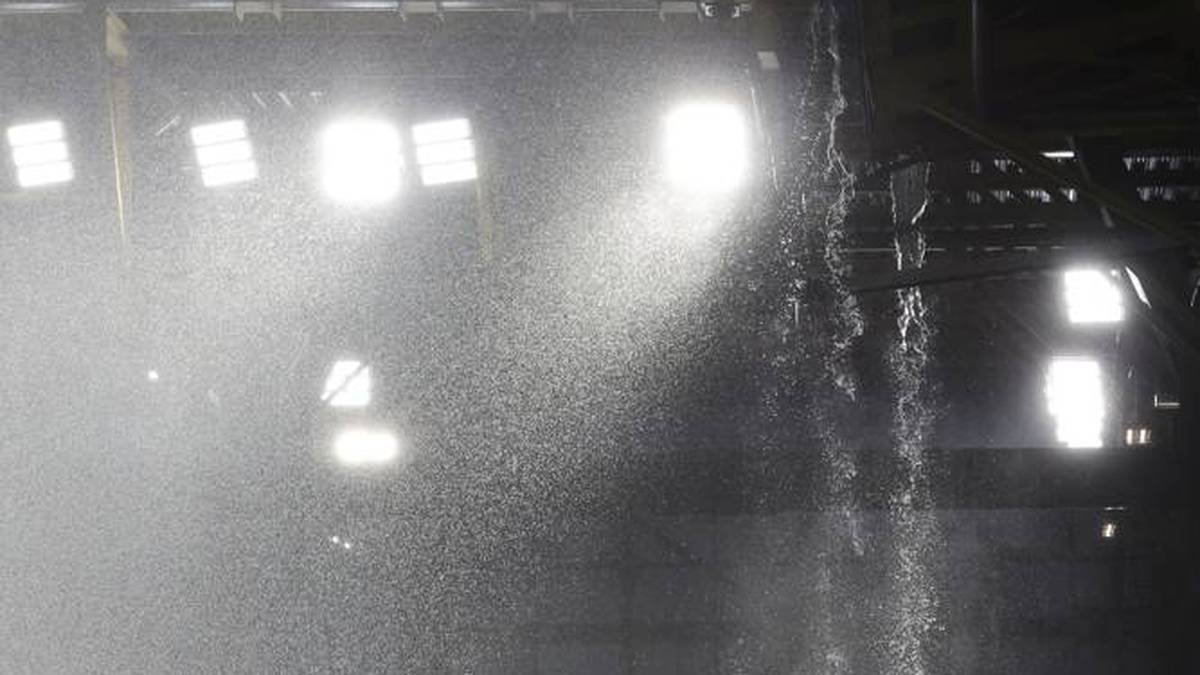 Das Regenwasser läuft wie von einem Wasserfall vom Stadiondach. 