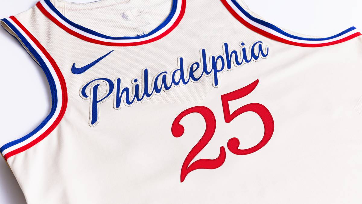 PHILADELPHIA 76ERS: Das Trikot ehrt Philly's Geist der Hingabe mit Farben, die vom Pergamentpapier der Verfassung inspiriert sind und mit einem asymmetrischen Streifen-Detail an den Seiten, das den berühmten Riss in der Freiheitsglocke nachahmt