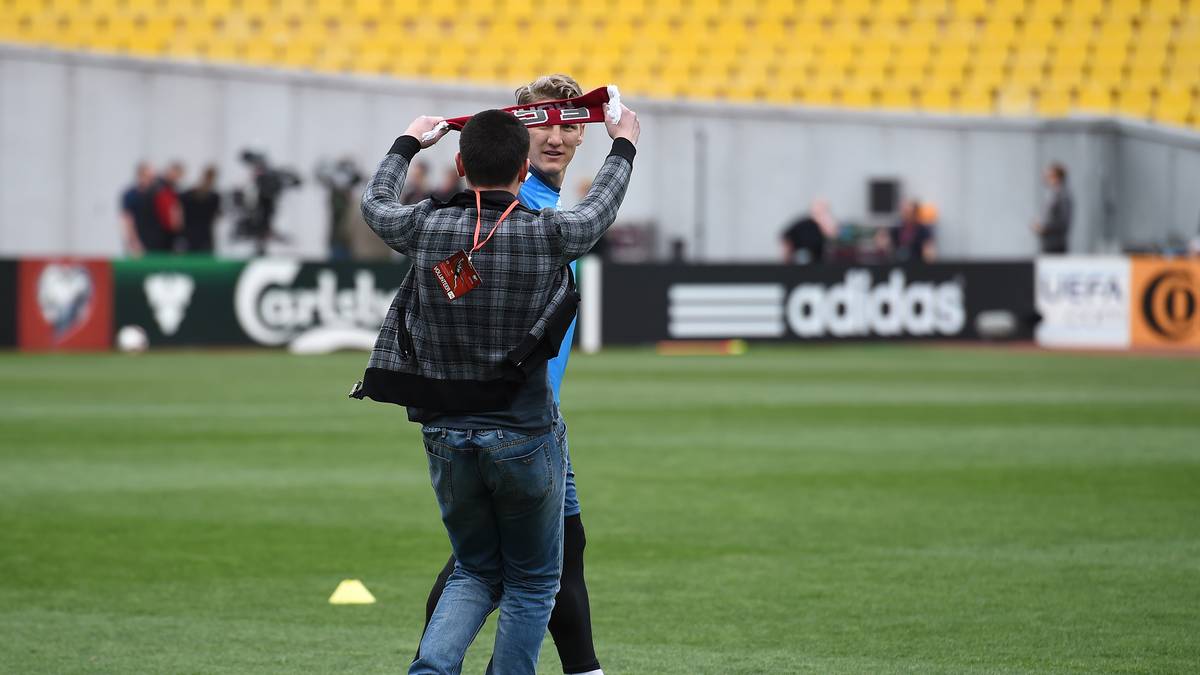 Der ungebetene Gast hat es auf Bastian Schweinsteiger abgesehen und stürmt mit einem Schal in der Hand auf den DFB-Kapitän zu