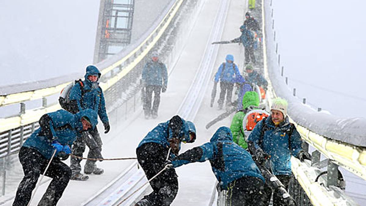 Helfer müssen ausrücken, um die Anlaufspur vom vielen Schneefall zu befreien. Es wird gefräst, gesägt und gewischt - der Durchgang startet planmäßig