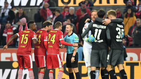 COLOGNE, GERMANY - NOVEMBER 08: 1. FC Koeln players confront referee Robert Kampka after TSG 1899 Hoffenheim score their team's second goal, a penalty awarded to them following a VAR review during the Bundesliga match between 1. FC Koeln and TSG 1899 Hoffenheim at RheinEnergieStadion on November 08, 2019 in Cologne, Germany. (Photo by Jörg Schüler/Bongarts/Getty Images)