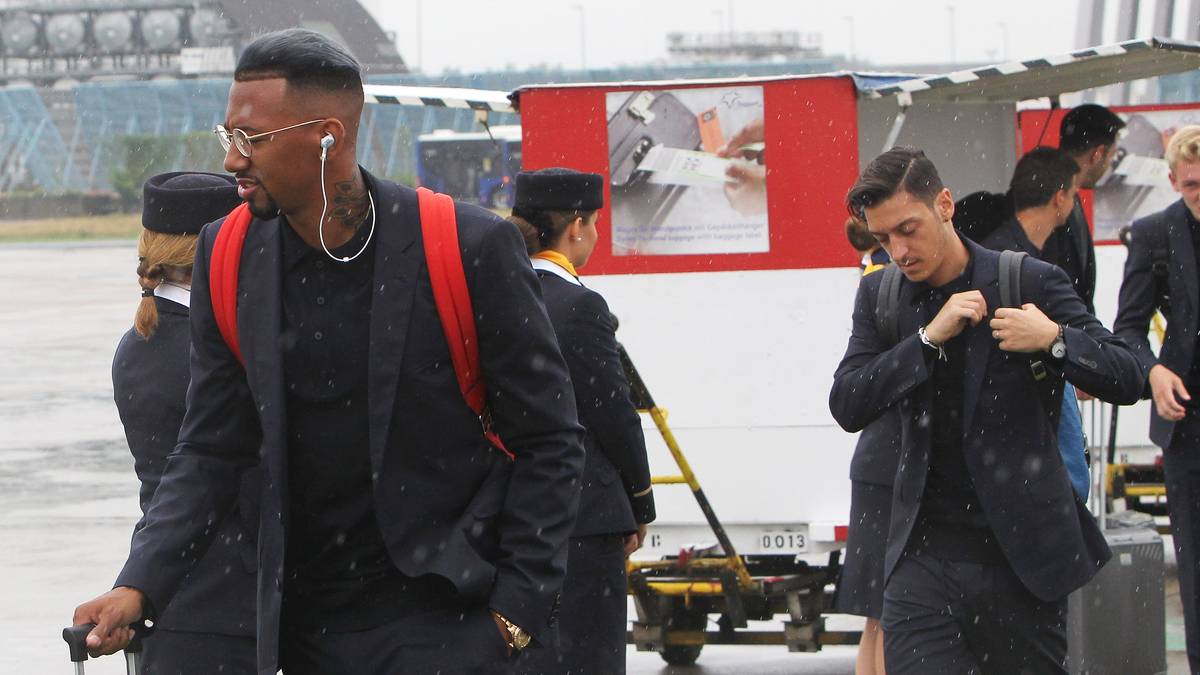 Auf dem Rollfeld gibt es ein gewohntes Bild: Jerome Boateng (l.) mit Kopfhörern, Mesut Özil in sich gekehrt
