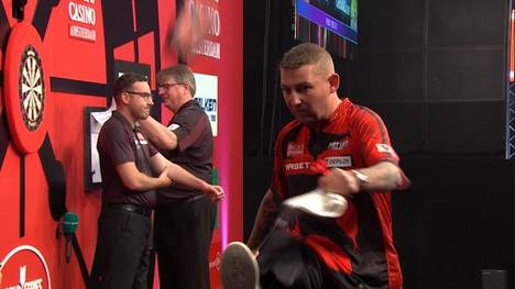 Nathan Aspinall verliert sein erstes Spiel bei den World Series of Darts Finals gegen Dave Chisnall - und kickt verärgert seine Utensilien von der Bühne.