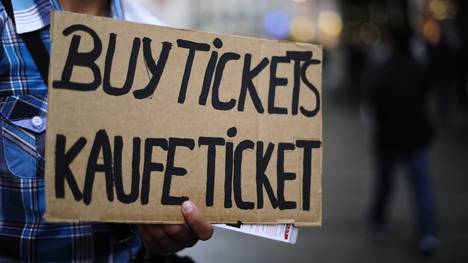 A person holds a poster asking for buyin