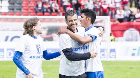 Marcel Schlosser (l.) und Tarek Chahed vom 1. FC Magdeburg feiern mit Cheftrainer Jens Härtel den Aufsteig in die 3. Liga in Offenbach