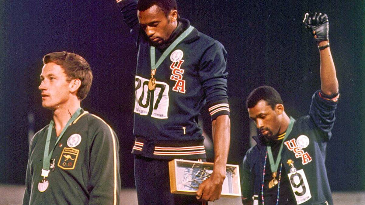 "Wenn ich siege, bin ich Amerikaner, kein schwarzer Amerikaner. Aber wenn ich etwas Schlechtes mache, sagen sie, ich sei ein Neger", sagte Smith später. Oft übersehen wird auf dem aussagestarken Bild der zweitplatzierte Australier Peter Norman (l.): Aus Solidarität mit Smith und Carlos trug er einen Anstecker des "Olympic Project for Human Rights". Das rechneten ihm die beiden zeitlebens hoch an: 2006 reisten Smith und Carlos als Trauerredner und Sargträger zu Normans Beerdigung nach Australien