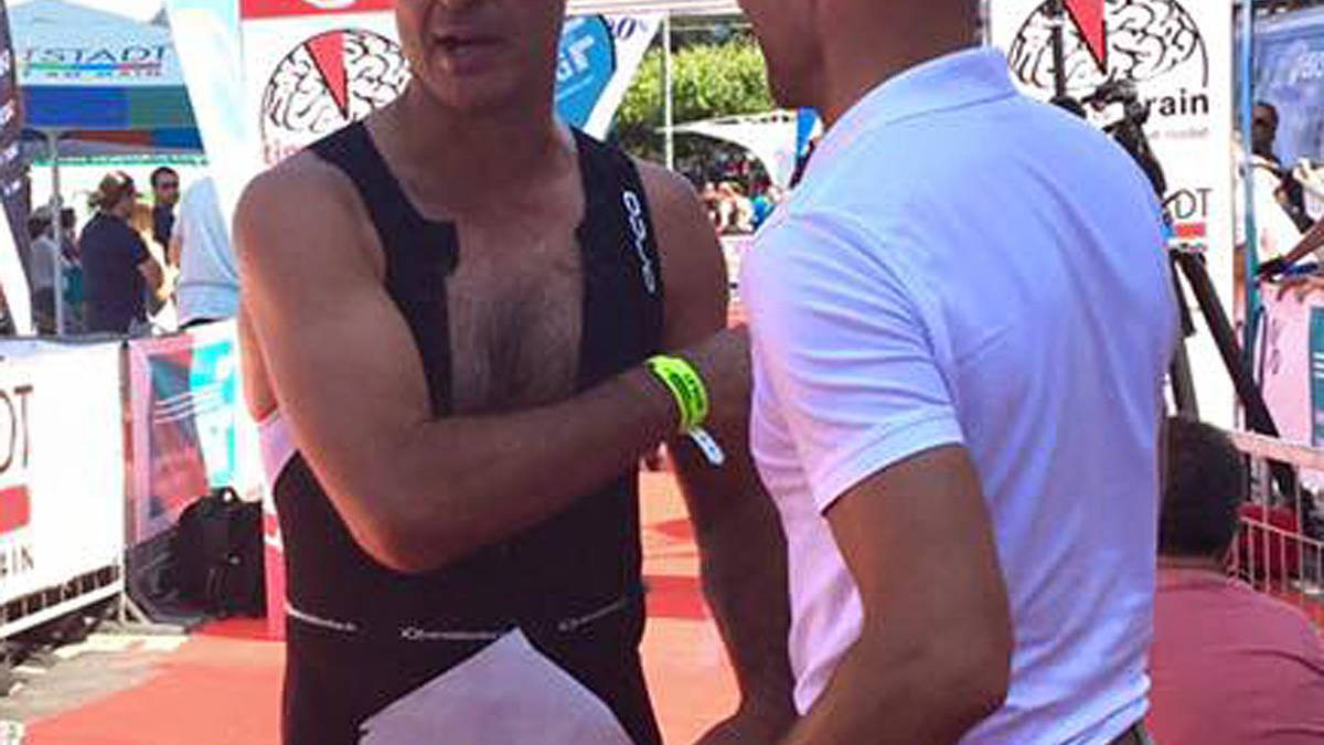 Thomas Berthold bekommt seine Teilnehmerurkunde beim Triathlon in Frankfurt