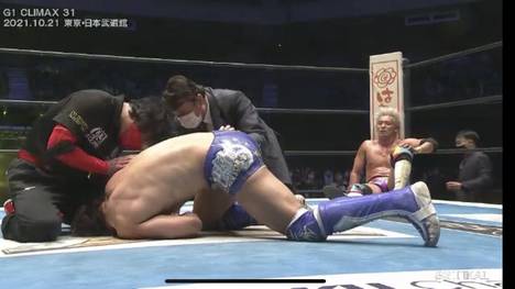 NJPW- G1 Climax Sieger Kazuchika Okada sitzt in der Ringecke und betrachtet den verletzten Kota Ibushi