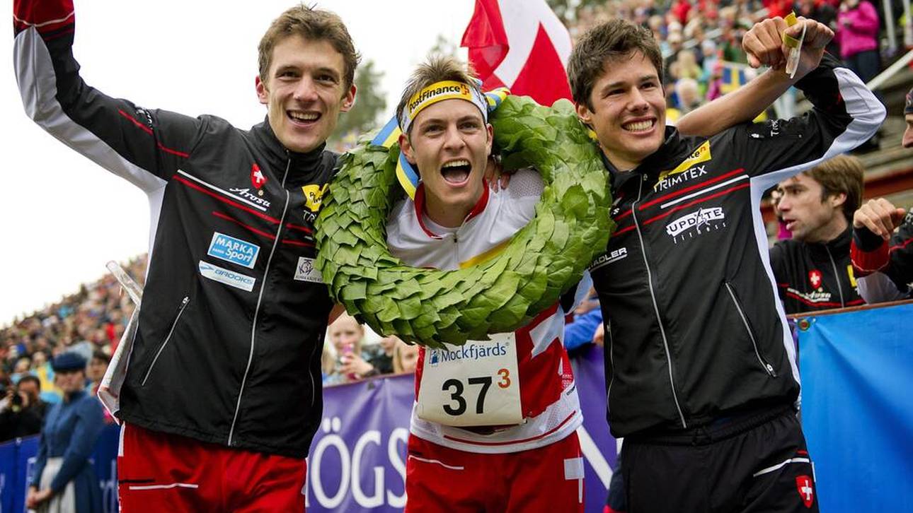 Matthias Kyburz (Mitte) 2012 nach einem Sieg im Orientierungslauf 