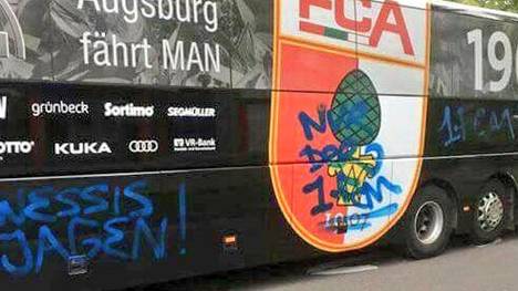 Augsburgs Stadionsprecher Rolf Störmann zeigt den Mannschaftsbus nach dem Vorfall bei Twitter