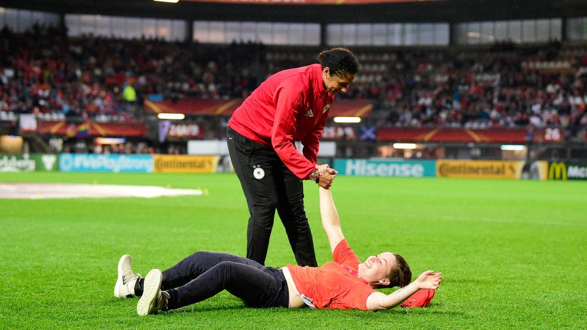 Bundestrainerin Steffi Jones hilft diesem weggerutschten Volunteer deshalb auf die Beine  