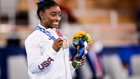 Superstar Simone Biles steht bei ihrer Rückkehr nach ihrer Auszeit im Fokus. Am Schwebebalken holt sie eine historische Medaille.