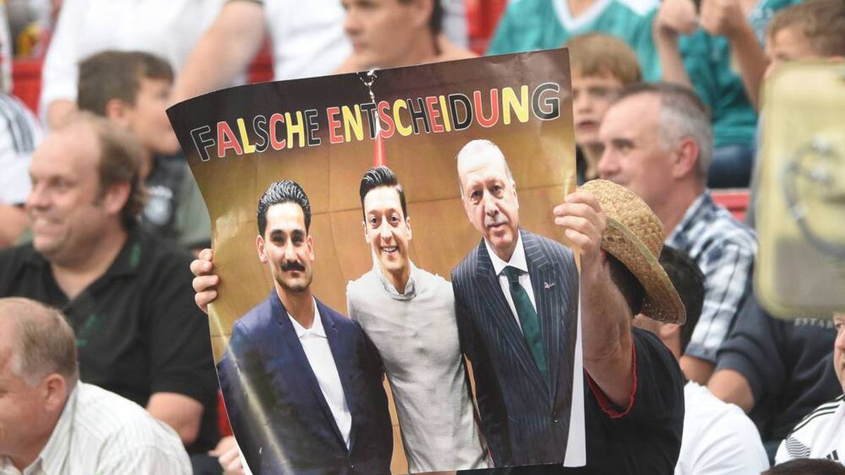 Deutsche Fans halten ein Plakat mit dem umstrittenen Foto von Gündogan, Özil und Erdogan hoch