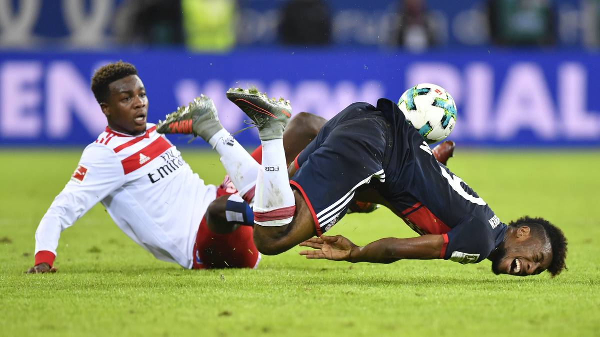 9. SPIELTAG: HSV - BAYERN (0:1). Jung tritt Coman in vollem Lauf auf die Ferse, der Münchner wälzt sich über den Rasen. Schiri Fritz bedient sein Headset...