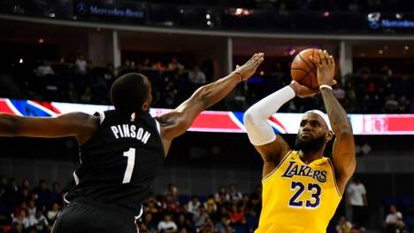 LeBron James of the Los Angeles Lakers (R) shoots past Theo Pinson of the Brooklyn Nets during the National Basketball Association (NBA) pre-season game between the LA Lakers and Brooklyn Nets at the Mercedes Benz Arena in Shanghai on October 10, 2019. (Photo by HECTOR RETAMAL / AFP) (Photo by HECTOR RETAMAL/AFP via Getty Images)