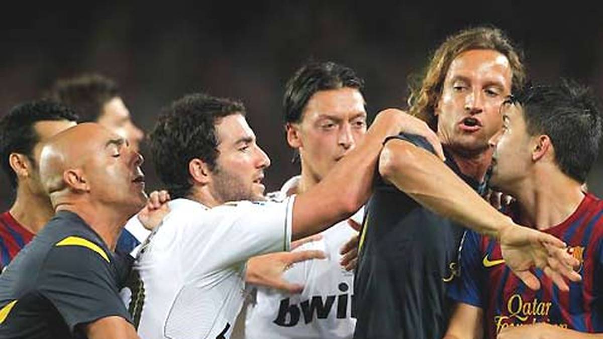 Ein Tiefpunkt in der Historie des Clasico ist der Supercup 2011. Nach einem 2:2 im Hinspiel gewinnen die Katalanen das zweite Duell im heimischen Barcelona mit 3:2. Wie so oft geraten beide Teams aneinander. Auch Özil (M.) beteiligt sich an der Keilerei und sieht Rot. Genauso wie sein Teamkollege Marcelo, der mit einem brutalen Foul die Rudelbildug erst auslöst, und Barcas David Villa (r.)