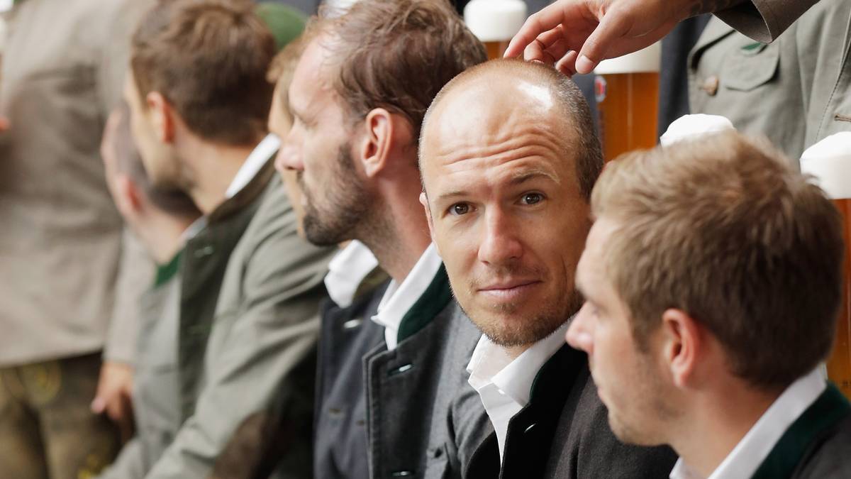 Arjen Robben und Philipp Lahm sitzen in der ersten Reihe und warten auf den Beginn des Fotoshootings