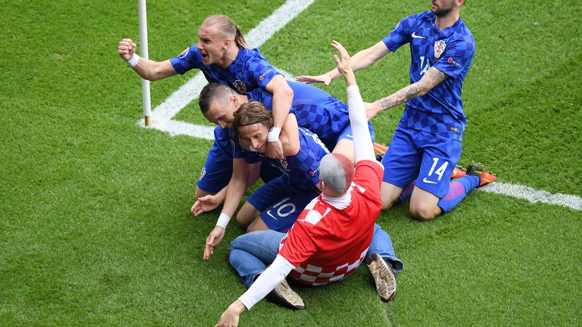 Die Freude über den sehenswerten Führungstreffer von Luka Modric beim Spiel Kroatien gegen die Türkei nahm dieser Fan zum Anlass, über die Bande der Zuschauerränge zu springen und mit den Spielern zu feiern. Den Ordnern gefiel das natürlich gar nicht