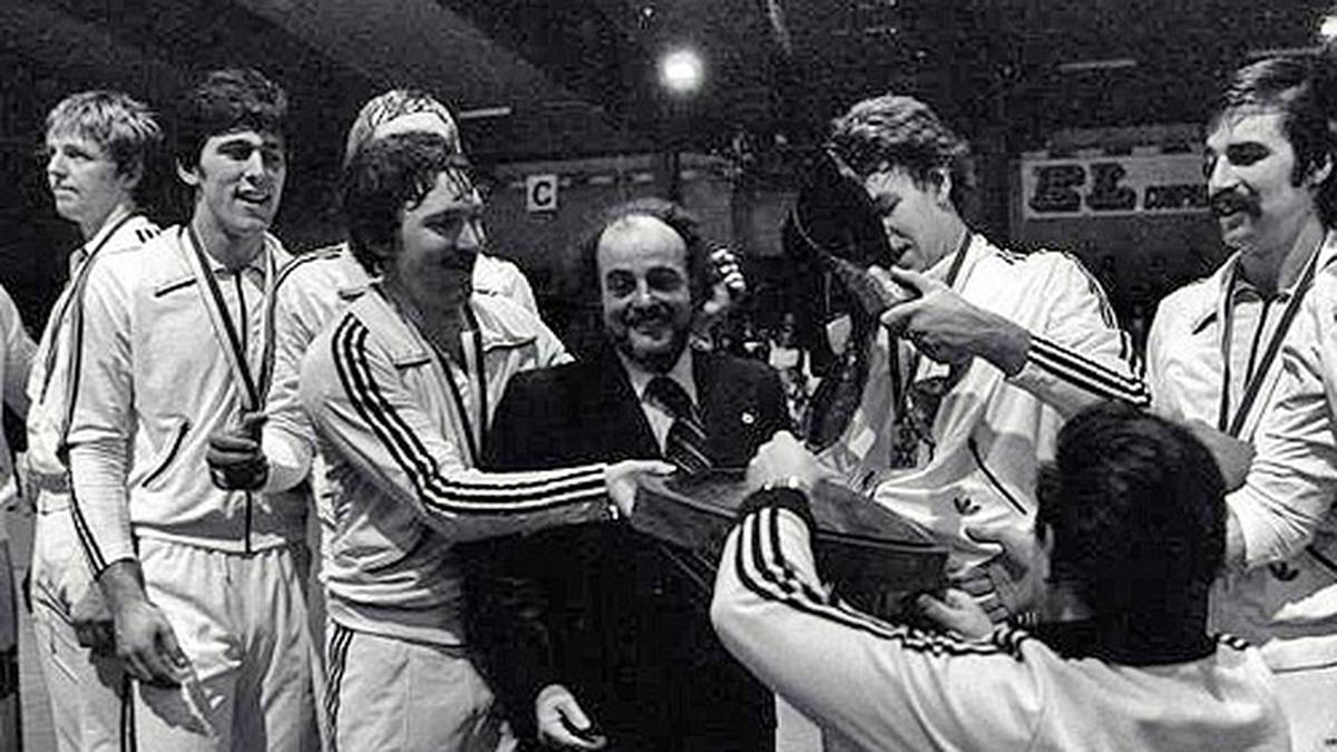 Im Finale bezwingt das Team von Trainer-Legende Vlado Stenzel (m.) die Sowjetunion mit 20:19 und startet eine Ära im deutschen Handball. An der Seite von Wunderlich (1. v. li.) spielen unter anderem Heiner Brand (1. v. re.) und Joachim Deckarm