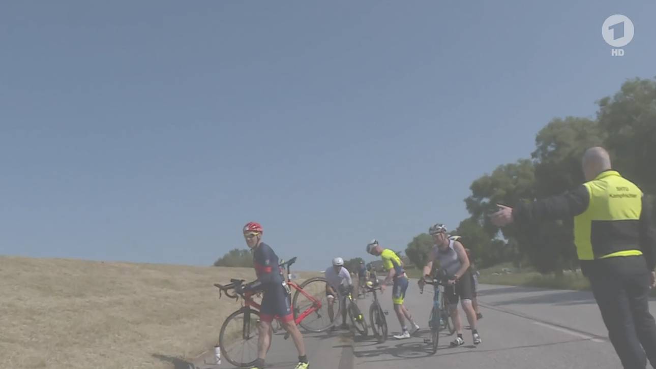 Die Ironman-Starter mussten ihre Fahrräder wegen des Unfalls auf einen Deich hinauftragen