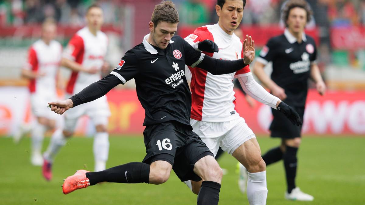 Der Mainzer Bell schlägt den Ball nach vorne, der Augsburger Ji kommt zu spät