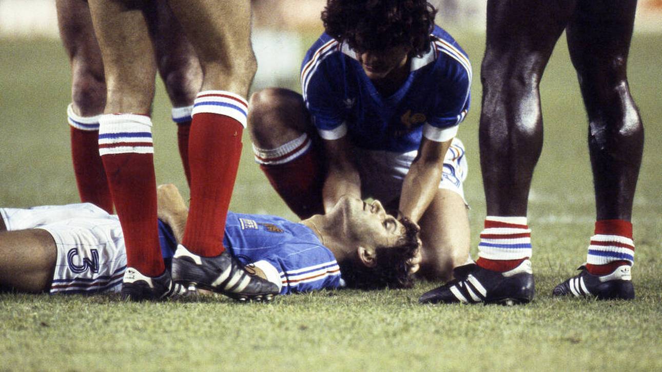 Dominique Rocheteau (r.) kümmert sich um den verletzt am Boden liegenden Patrick Battiston (FRA), nach dem Foul durch Toni Schumacher