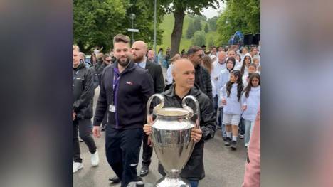Die Trophäe der UEFA Champions League ist in München angekommen. Eine Fußballlegende trägt das Objekt der Begierde in den Olympiapark.