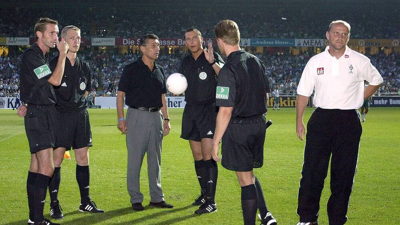 Rudi Assauer (Schalke, 3. v. li.) und Thomas Schaaf (r) beraten sich mit Schiedsrichter Stefan Trautmann über die weitere Vorgehensweise nach dem Stromausfall