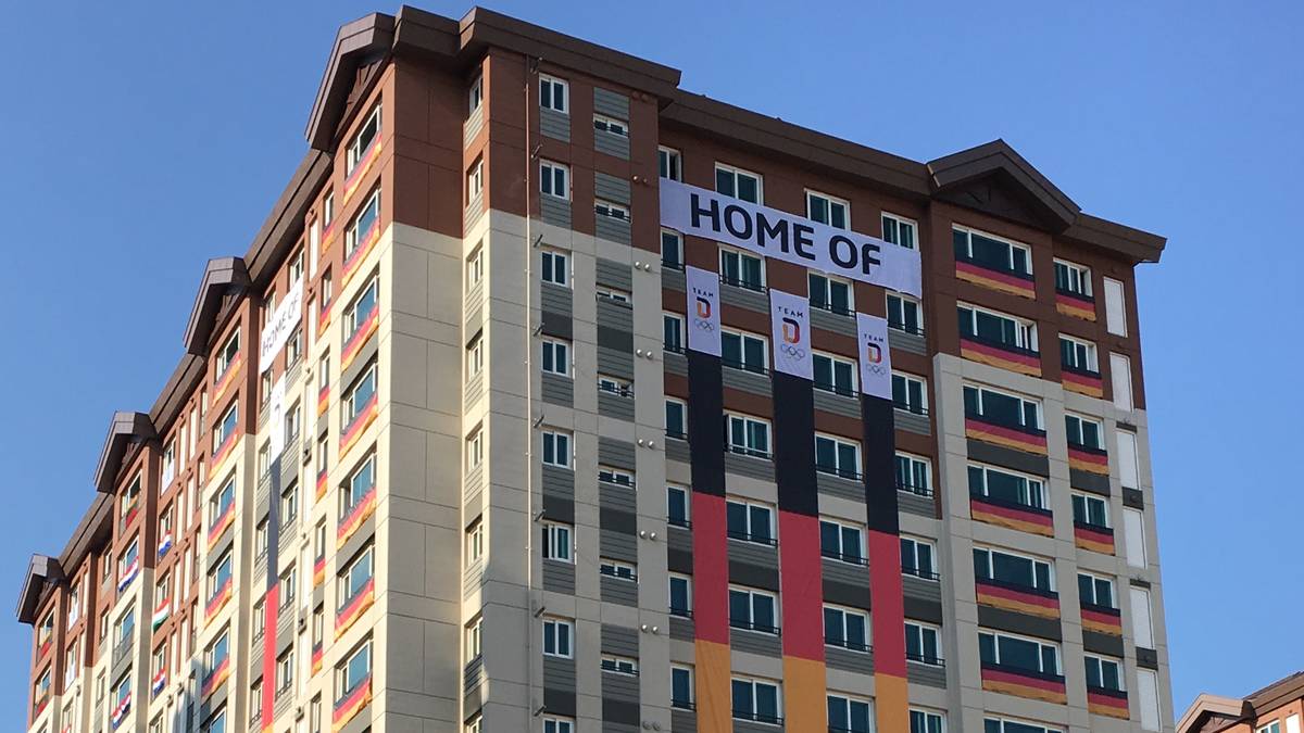 Unverkennbar steht mitten im Dorf die Unterkunft des deutschen Olympia-Teams - gekennzeichnet durch eine riesige deutsche Flagge