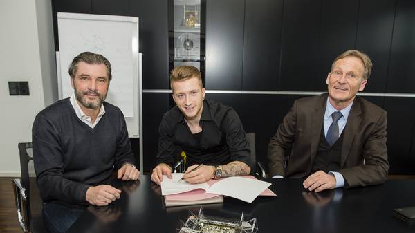 Marco Reus (M) unterzeichnet im Februar 2015 neben Michael Zorc (L) und Hans-Joachim Watzke seinen neuen Vertrag