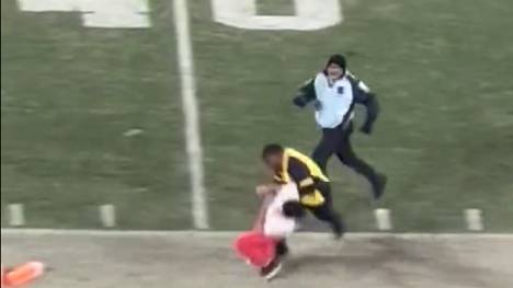 Beim Collegespiel von USC gegen UCLA streckt ein Security-Guard einen Flitzer mit einem Monster-Tackle nieder.