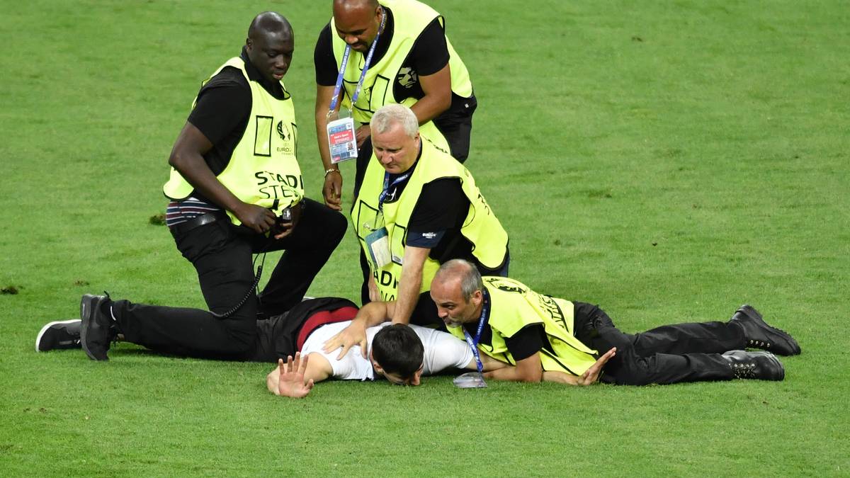 Der junge Mann wird von den Sicherheitskräften jedoch aufgehalten, bevor er einem Spieler zu nahe kommen kann