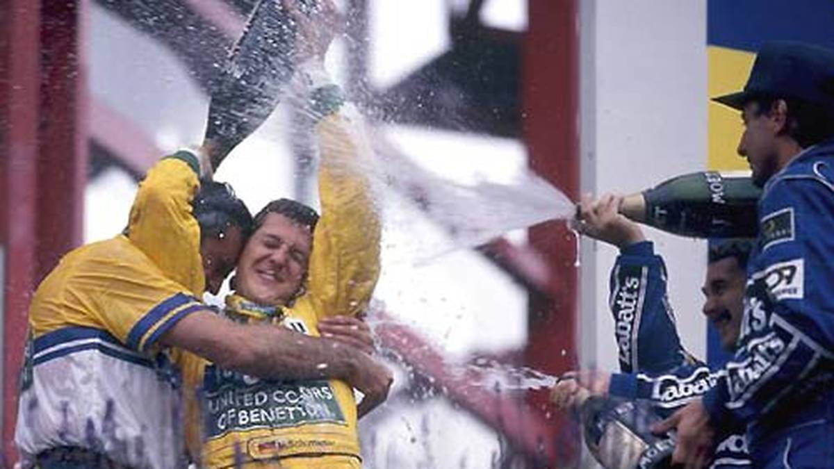 Den Umgang mit dem Sieger-Champagner beherrscht er zusammen mit seinem damaligen Teamchef Flavio Briatore (l.) indes schon recht gut