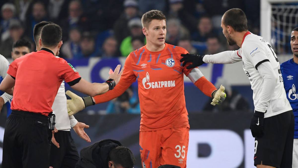 Schalke's German goalkeeper Alexander Nuebel (C) argues with Referee Felix Zwaye (L) and Frankfurt's Dutch forward Bas Dost after beeing shown a red card during the German first division Bundesliga football match Schalke 04 v Eintracht Frankfurt in Gelsenkirchen, on December 15, 2019. (Photo by INA FASSBENDER / AFP) / DFL REGULATIONS PROHIBIT ANY USE OF PHOTOGRAPHS AS IMAGE SEQUENCES AND/OR QUASI-VIDEO (Photo by INA FASSBENDER/AFP via Getty Images)