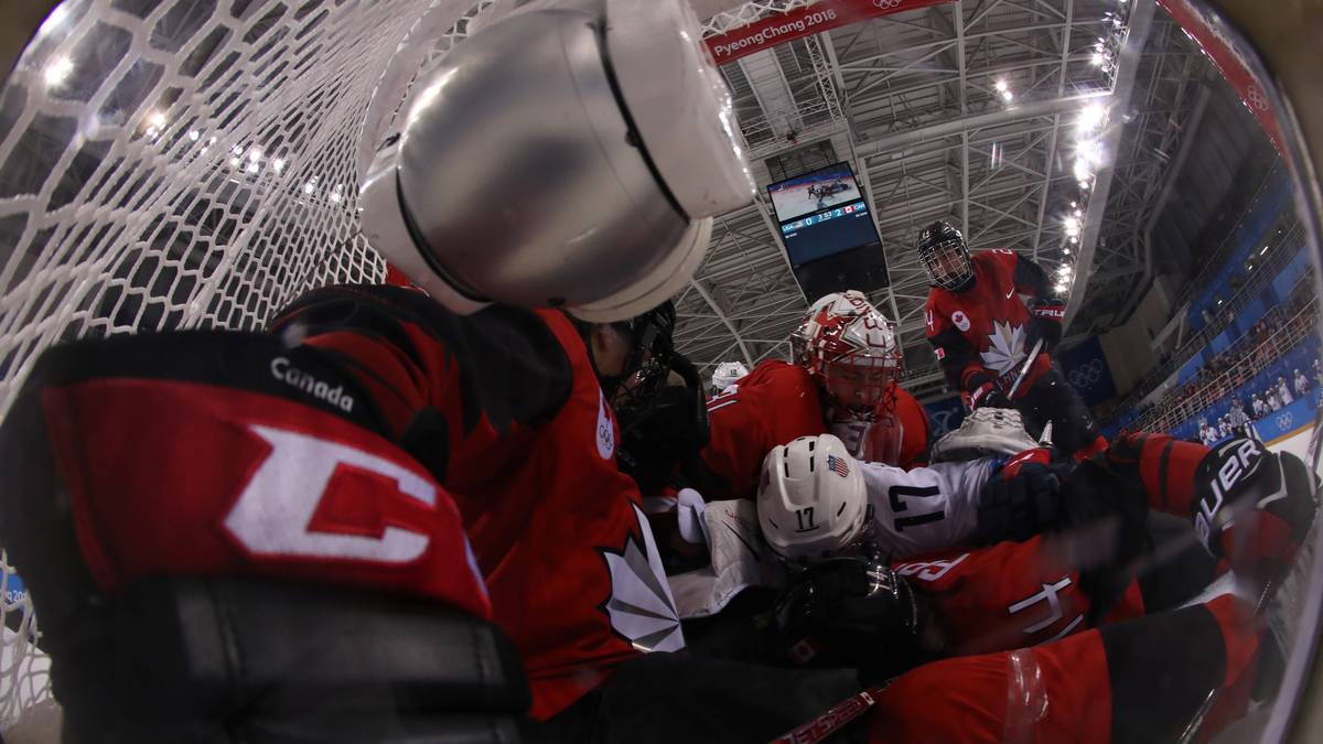 Ganz schön unübersichtlich: Beim Eishockey krachen Spielerinnen der USA und Kanada ins Tor