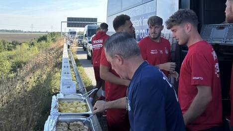 Der FSV Zwickau zeigt, wie seine Spieler im Stau ihr Abendessen auf der Leitplanke serviert bekommen