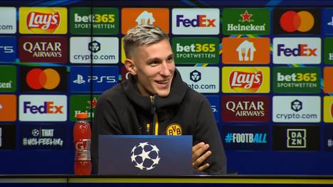 Nico Schlotterbeck wird vor dem Champions-League-Spiel gegen Athletic Bilbao auf seine Vertragssituation angesprochen. Der BVB-Star grinst verlegen.