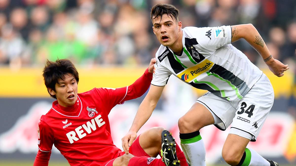 MOENCHENGLADBACH, GERMANY - FEBRUARY 14:  Yuya Osako of 1.FC Koeln challenges Granit Xhaka of Borussia Moenchengladbach during the Bundesliga match between Borussia Moenchengladbach and 1. FC Koeln at Borussia Park Stadium on February 14, 2015 in Moenchengladbach, Germany.  (Photo by Lars Baron/Bongarts/Getty Images)