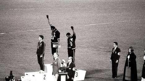 Tommie Smith (M.) und John Carlos reckten 1968 bei der Siegerehrung die Faust in die Höhe